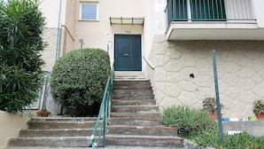 A set of stone steps leading to a dark green door with a small window above it. - Casa Barbara (Bogliasco)