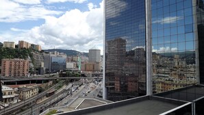 A modern building with a glass facade reflecting the cityscape. - House Asfodelo (Genoa)
