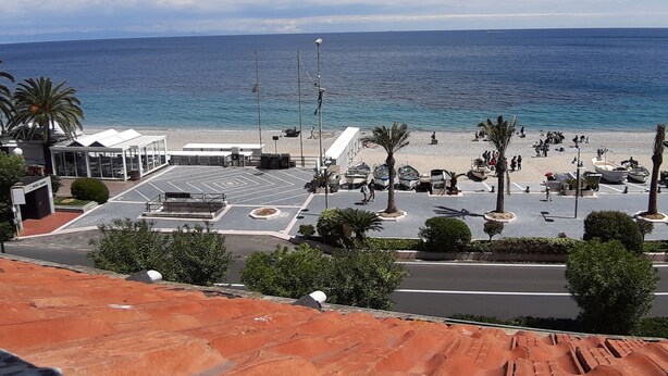 A coastal view with a parking area, beach, and ocean. - Sea Attic (Noli)