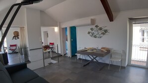 A modern living room with a dining area, a staircase, and a view of the outside balcony. - La Torre (Bogliasco)