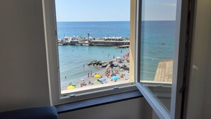A room with a large window overlooking a beach. - La Torre (Bogliasco)