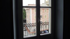 A window with a view of a street and buildings. - Azzurro Pervinca (Finale Ligure)