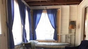 Een kamer met een bed, een bureau, een stoel en een blauwe bank.