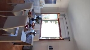 A compact living space with a dining area, a kitchen, and a seating area with a sofa.
