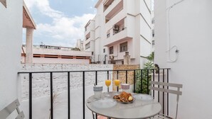 A balcony with a table set for two, featuring a glass of orange juice, a croissant, and a plate of cookies. - MY LOFT 4 YOU RUZAFA STYLE II (Valencia)