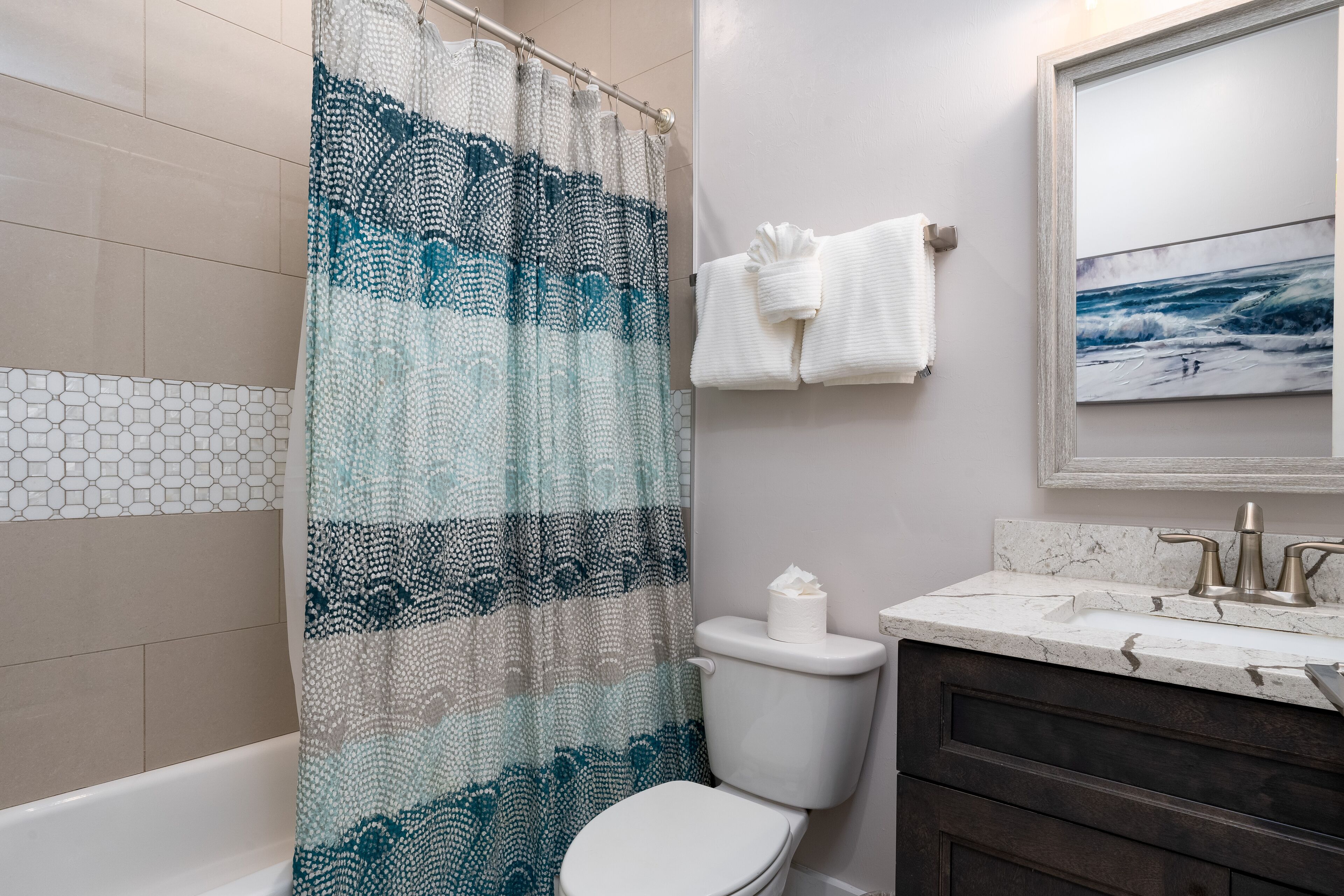 A bathroom with a shower curtain, toilet, sink, and towel rack.