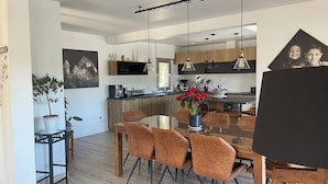 A modern kitchen with wooden cabinets, a central island, and pendant lighting. - Large Villa - Charming Provencal village - Swimming pool - Petanque court (PEYNIER)
