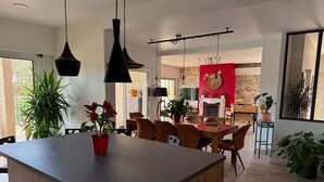 A modern kitchen with a central island, wooden cabinets, and pendant lighting. - Large Villa - Charming Provencal village - Swimming pool - Petanque court (PEYNIER)