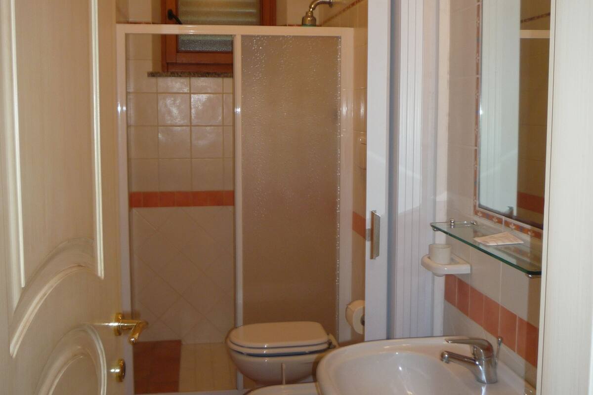 A compact bathroom with a toilet, bidet, and sink.