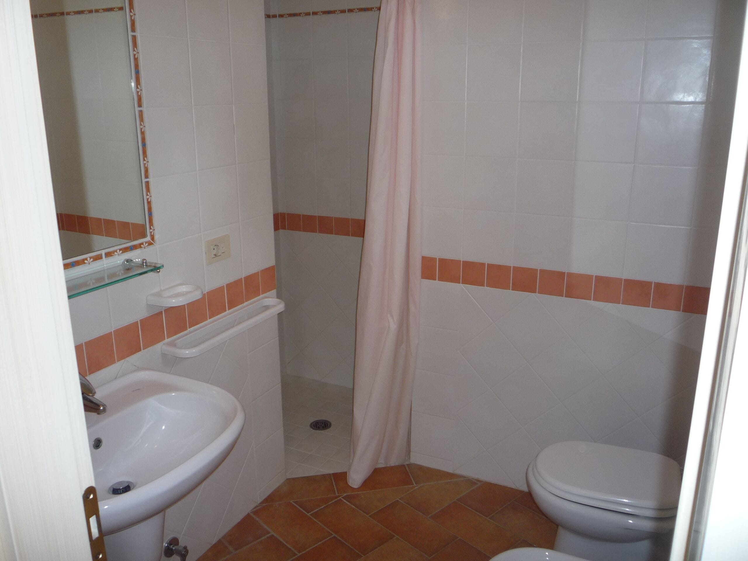 A bathroom with a sink, toilet, and shower curtain.