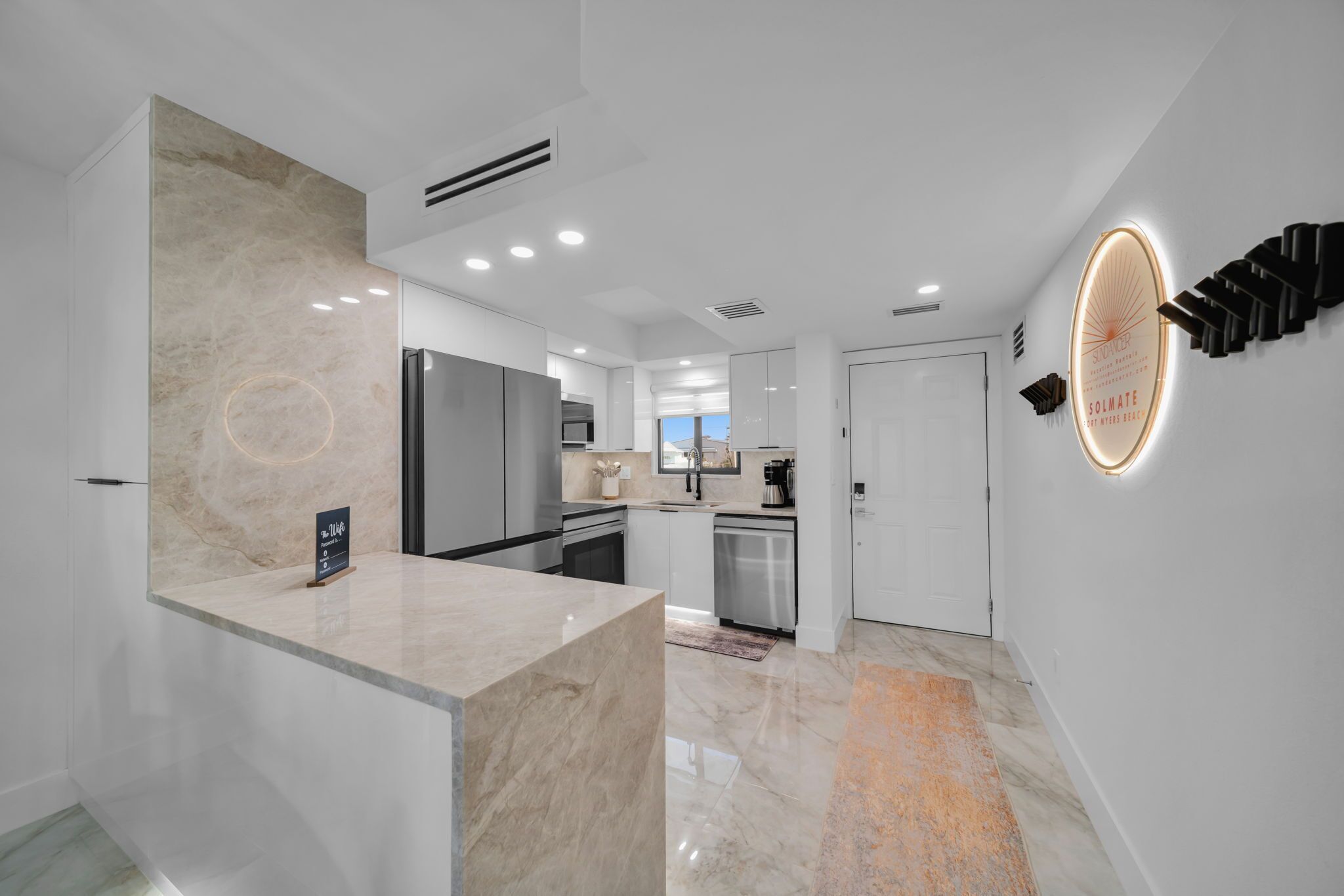 A modern kitchen with a marble countertop, stainless steel appliances, and a built-in oven.