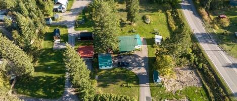 An aerial view of a rural property with multiple buildings, a road, and surrounding greenery.