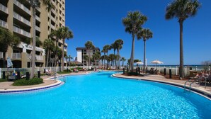 A swimming pool surrounded by palm trees and a hotel building. - L👀K!!! ⭐️ TOP RATED CONDO ⭐️ 3 Pools ⭐️ Breathtaking Ocean Views !!! (Panama City Beach)