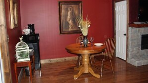 A dining room with a wooden table, chairs, a vase with dried plants, and a painting on the wall. - Lazy G #1 Honeymoon Suite (Union Grove)