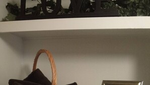 Une étagère avec un panier en osier, une photo encadrée et une petite bouteille.