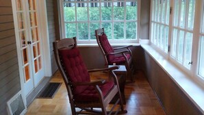 A room with wooden flooring, two rocking chairs, large windows, and a ceiling light. - Governor's Home (Historic Property) (Cheyenne)