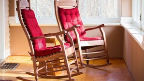 Two rocking chairs with red cushions in a corner by a window. - Governor's Home (Historic Property) (Cheyenne)