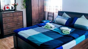 Quarto com cama, guarda-roupa de madeira e espelho.