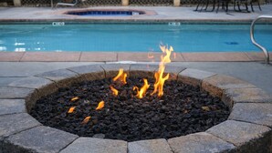 A pool area with a fire pit in the foreground and a pool in the background. - Snowblaze 310 Cozy Comfort in the Heart of Park City (Park City)
