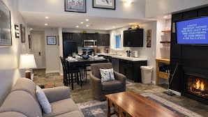 A modern living room with a fireplace, a dining area, and a kitchen. - Snowblaze 310 Cozy Comfort in the Heart of Park City (Park City)