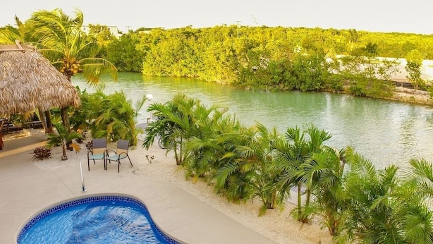 A swimming pool with a view of a river and lush greenery. - FALL SEASON 55% OFF RENTAL RATE (Marathon)