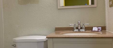 Une salle de bain équipée de toilettes, d’un lavabo et d’un porte-serviettes.