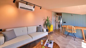 Una sala de estar moderna con sofá, mesa de centro y comedor con mesa y sillas.