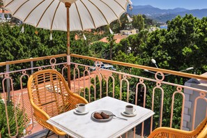 A balcony with a table, two chairs, and an umbrella. - Luff Boutique Hotel - Adults Only (Kas)
