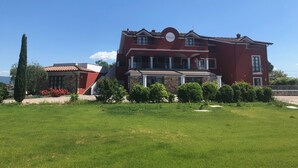 A two-story building with a red facade, a balcony, and a stone base. - Villa Nadar Hotel  B&B (Altopascio)