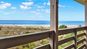 Blick vom Balkon auf einen Strand mit klarem Himmel und Meer.