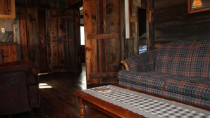 Ein rustikales Holzinterieur mit einem karierten Sofa, einer hölzernen Bank und einer karierten Tischdecke.
