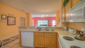 A kitchen with wooden cabinets, a dishwasher, a stove, and a microwave. - Emerald_island_8515n (Kissimmee)
