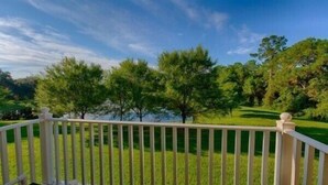 A deck with a view of a grassy area and trees. - Emerald_island_8515n (Kissimmee)