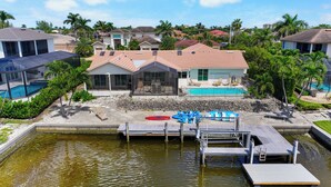 Zona residencial con piscina, muelle y una casa con porche cubierto.