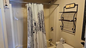A bathroom with a shower, toilet, and sink.