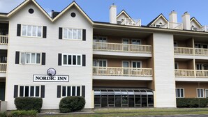 A Nordic Inn building with a sign, multiple balconies, and a parking lot.