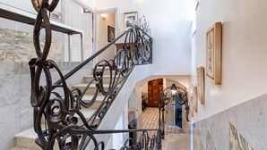 Eine prächtige Treppe mit aufwendiger Metallgalerie, die zu einer oberen Etage führt.