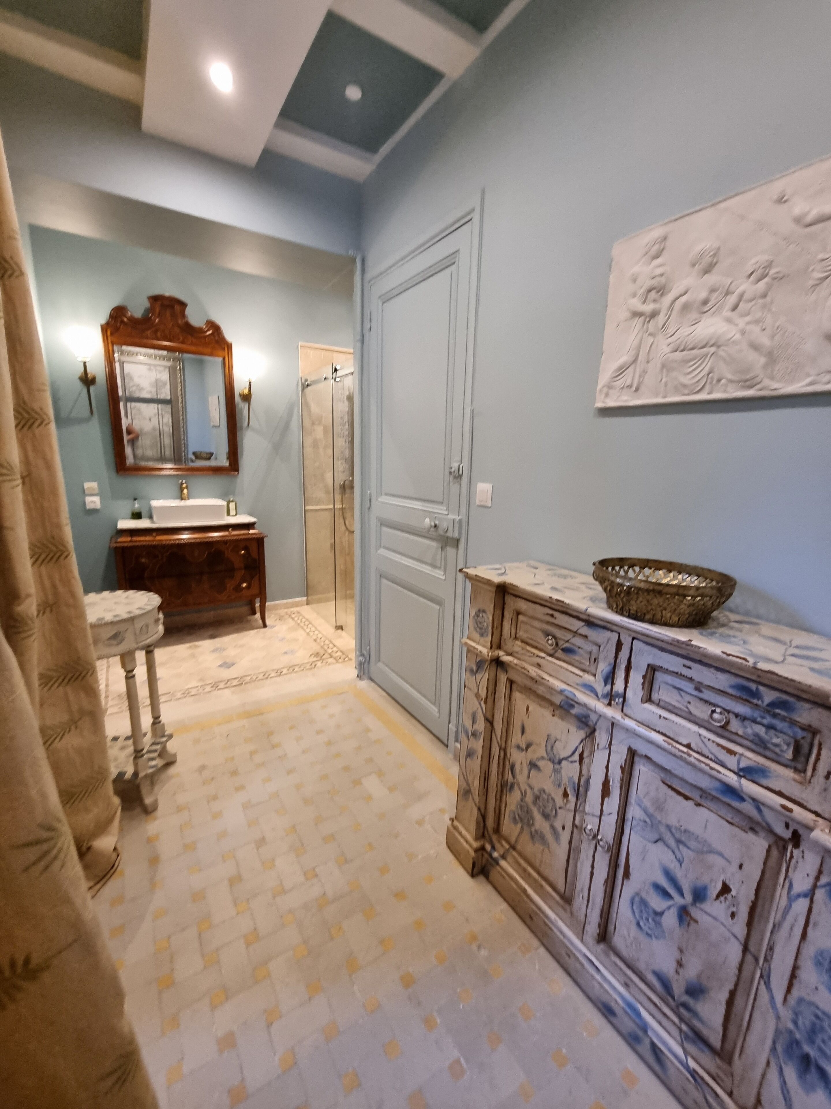 A bathroom with a sink, mirror, vanity, and a shower.