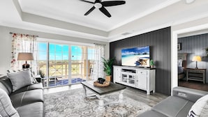 A modern living room with a sofa, coffee table, and TV. - Centre Ridge Escape | 3BR Modern Condo w/ Golf Course Views in Reunion Resort Near Disney (Kissimmee)