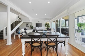 Relax in a spacious room with a dining table, flat-screen TV, and comfortable seating area.
