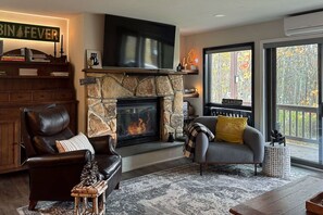 TV connectée, cheminée, livres, médiathèque