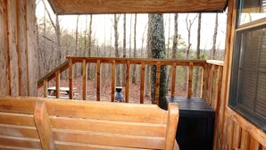 A wooden deck with a bench and a table, overlooking a forested area. - Couples Getaway Near Hot Springs-Jacuzzi and Hot Tub Overlooking Mountains! (Bismarck)