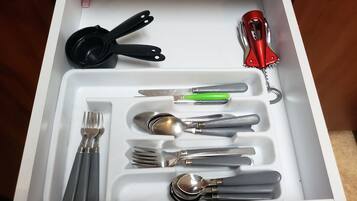 A drawer with various utensils neatly organized, including forks, spoons, and a knife.