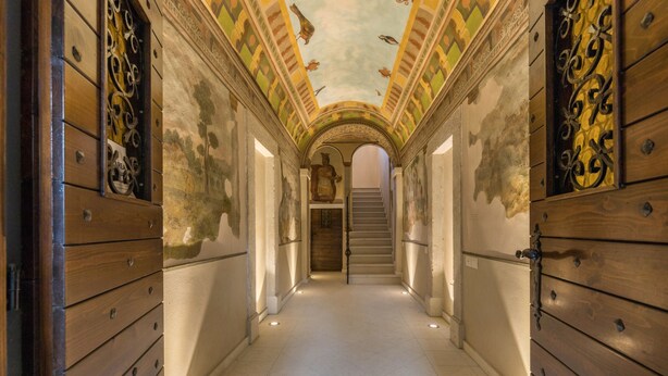 A hallway with wooden paneling, a staircase, and a mural on the ceiling. - Apartment "Ontano" in Agriturismo Style with Wi-Fi, Garden, and Shared Pool (Desenzano)