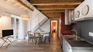 Eine moderne Küche mit integriertem Spülbecken, Holzboden und einer Treppe, die zu einer oberen Ebene führt.
