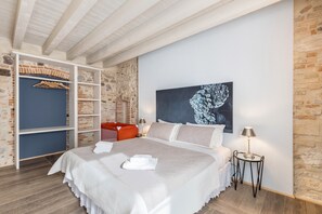 A bedroom with a bed, a wardrobe, a painting, and a nightstand.