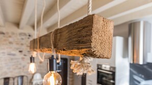 Una cucina rustica con pareti in mattoni a vista, travi in legno a soffitto e lampade a sospensione.
