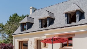 A two-story house with a sloped roof, stone exterior, and a patio with outdoor furniture. - Coët A Tous by Interhome (Carnac)