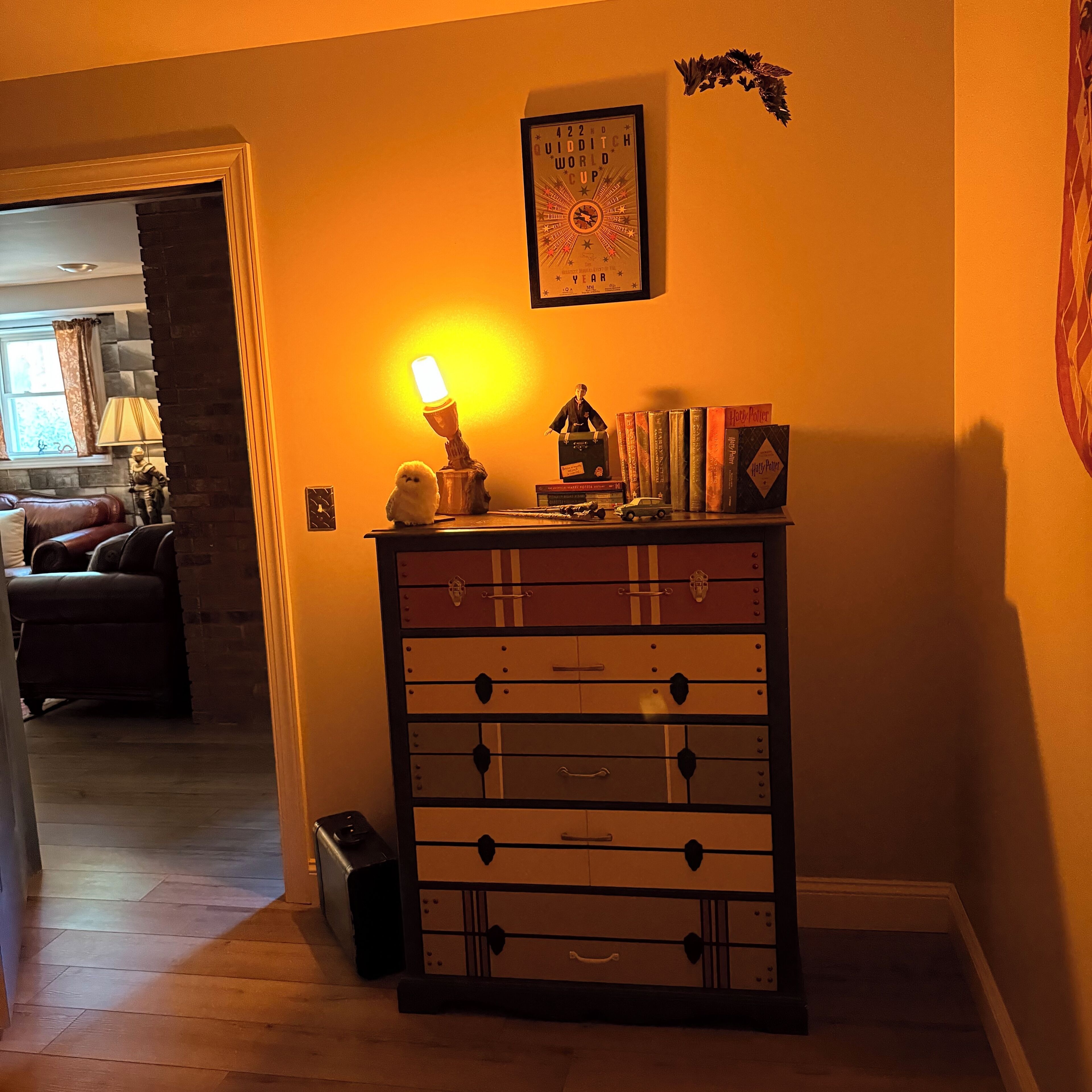 En hyggelig stue med pejs, en bogreol fyldt med bøger og en lampe.