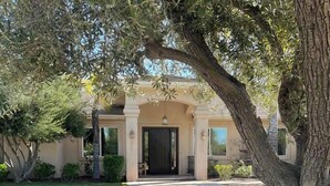 A residential house with a driveway leading to a front door, surrounded by trees and shrubs. - Wine Estate - Private Pickleball, Solar Pool, Golf (Temecula)
